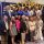 Group of adults posing for a group photo at a conference, with gold 'Celebrate' balloons and an American flag in the background.