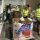 Volunteers in high-visibility vests sorting donation boxes in a warehouse.